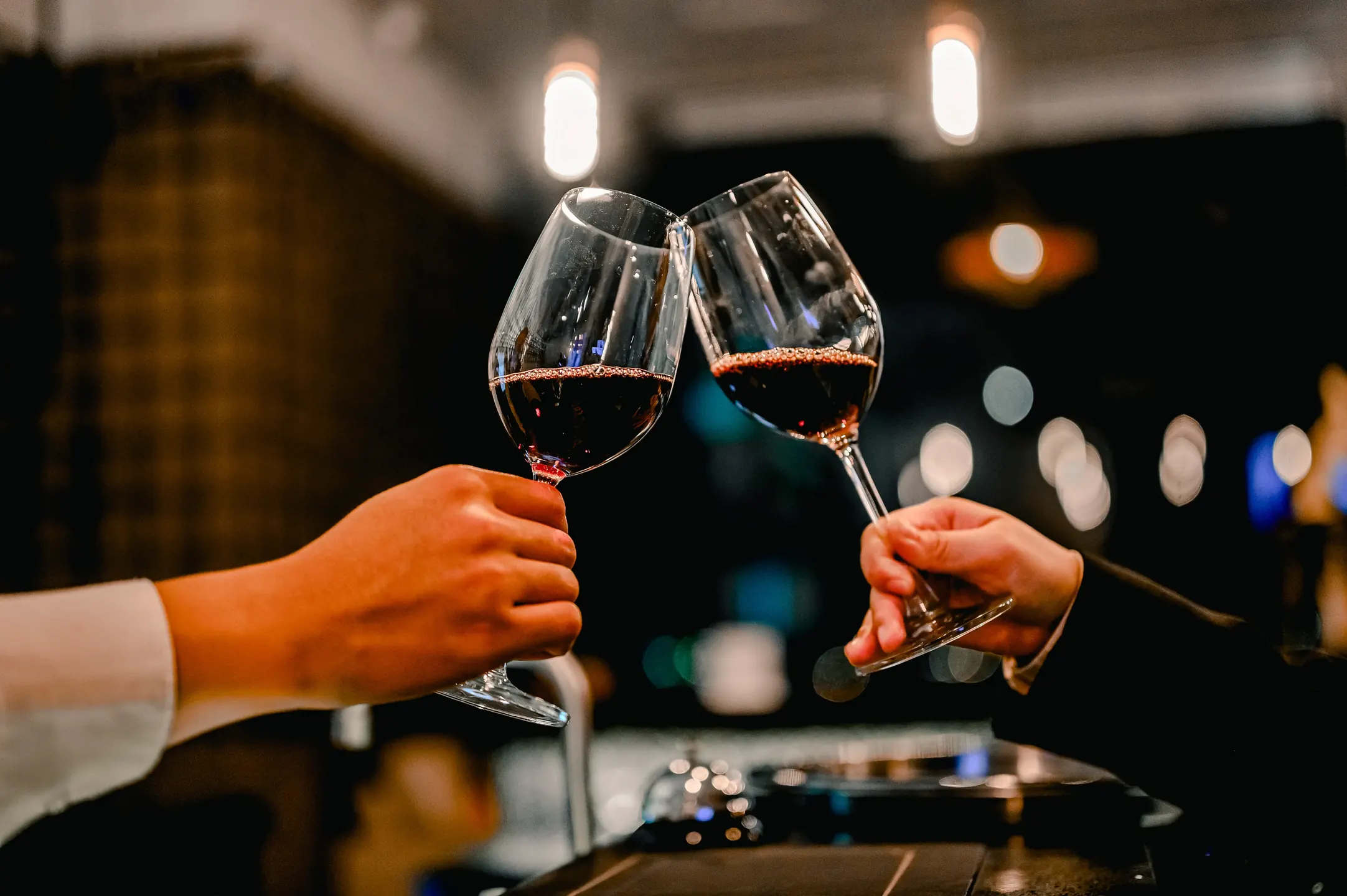 Zwei Personen stoßen mit Rotwein an